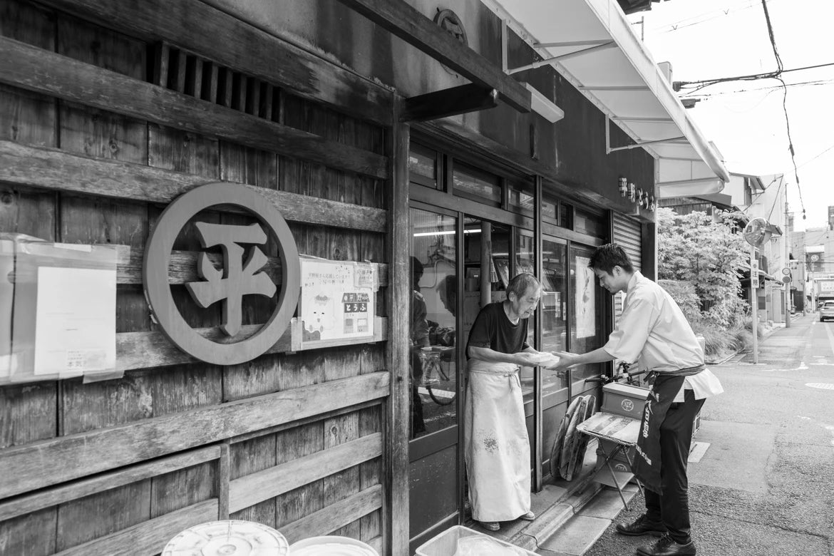 平野とうふの店先で豆富を受け渡す光景