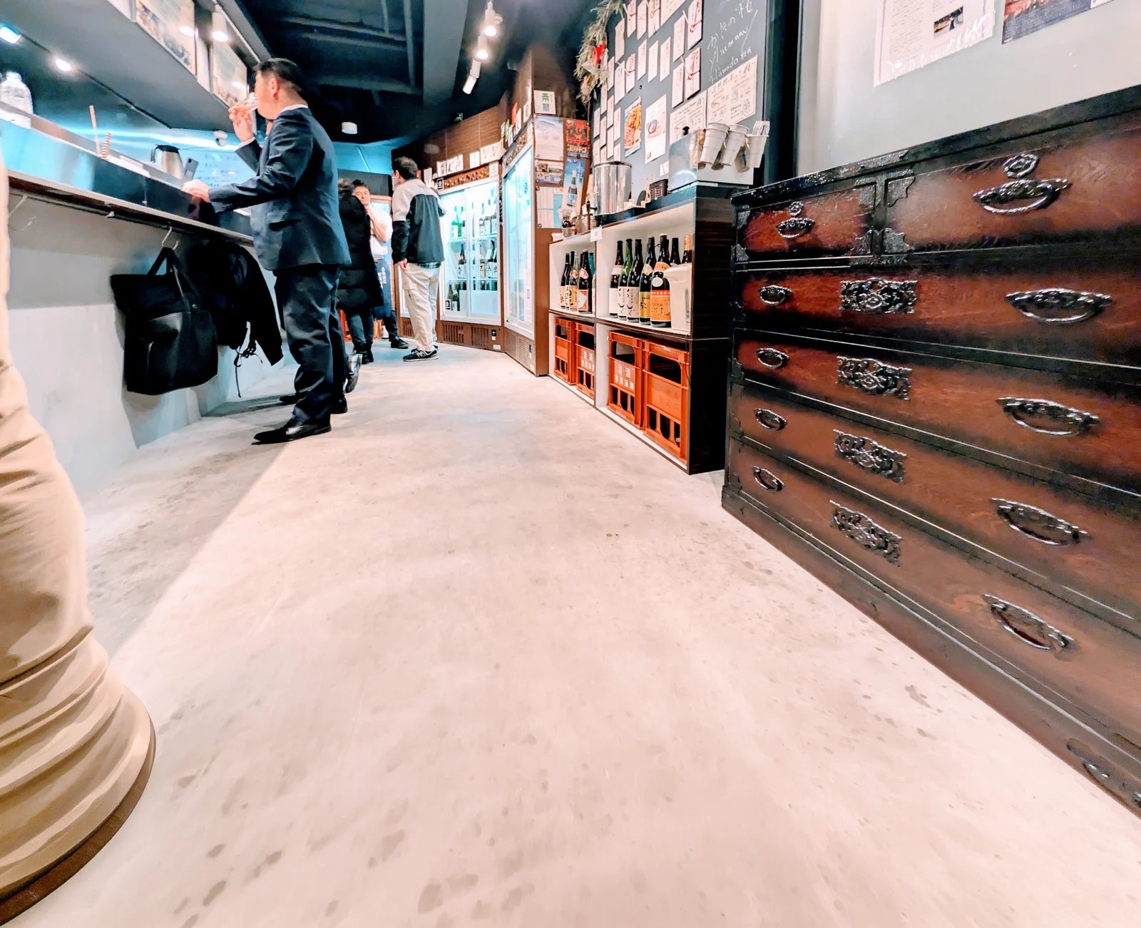 酒のショーケースと立ち呑みカウンターのある店内